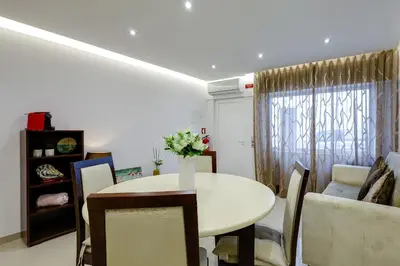 a living room with a white table and chairs at Casa Maguy in Albufeira