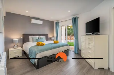 a bedroom with a bed and a chair and a window at #239 Vivenda V3 com Piscina by Home Holidays in Albufeira