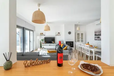 a bottle of wine sitting on a table in a living room at Host Wise - Serene Spacious House - Swimming Pool & Garden in Olhos de Água