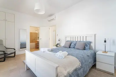 a bedroom with a large bed with towels on it at Host Wise - Serene Spacious House - Swimming Pool & Garden in Olhos de Água