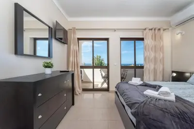 a bedroom with a bed and a dresser with a mirror at Host Wise - Bright Lovely Flat - Balcony in Guia