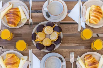a table with plates of pastries and a cup of coffee at Host Wise - Bright Lovely Flat - Balcony in Guia