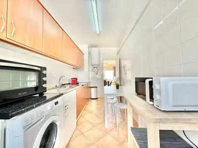 a kitchen with a washer and dryer on a counter at Sea Front 180º View with AC and WiFi in Quarteira