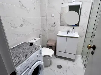 a white bathroom with a toilet and a sink at Casa Patricia in Albufeira