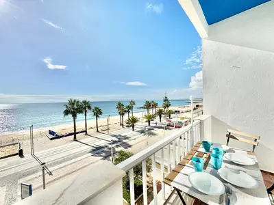 a balcony with a view of the beach at Direct Beach Access with Sea View, AC & WiFi in Quarteira