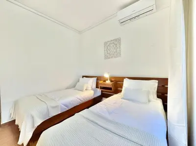 two beds in a room with white sheets at Direct Beach Access with Sea View, AC & WiFi in Quarteira