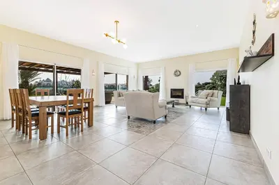 a dining room and living room with a table and chairs at Quinta dos Figos - Jacuzzi Perto da Praia in Guia