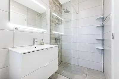 a white bathroom with a sink and a shower at Quinta dos Figos - Jacuzzi Perto da Praia in Guia