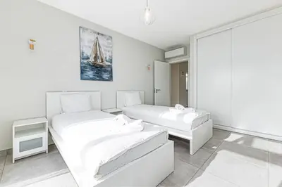 a white bedroom with two beds and a window at Quinta dos Figos - Jacuzzi Perto da Praia in Guia
