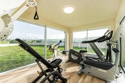 a gym with three exercise bikes in a room with windows at Quinta dos Figos - Jacuzzi Perto da Praia in Guia