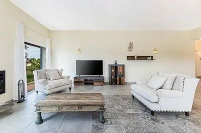 a living room with two couches and a flat screen tv at Quinta dos Figos - Jacuzzi Perto da Praia in Guia