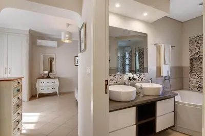 a white bathroom with two sinks and a tub and a tubermott at Casa das Buganvilias in Loulé