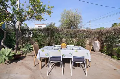 a table with chairs and a white table cloth at Casa das Buganvilias in Loulé