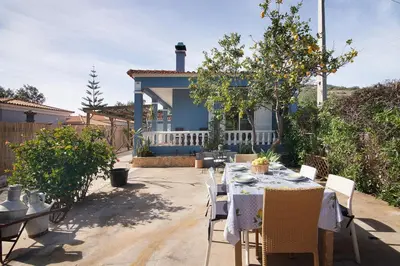 a table and chairs in front of a house at Casa das Buganvilias in Loulé