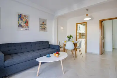 a living room with a blue couch and a table at Cozy Apt 5min Beach Ocean View AC Wi Fi in Albufeira