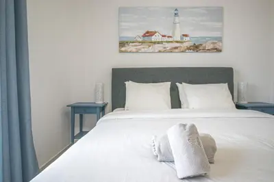 a bedroom with a white bed and a lighthouse at Cozy Apt 5min Beach Ocean View AC Wi Fi in Albufeira