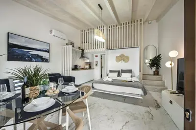a living room with a bed and a dining table at Alcaçarias Suite 20 in Faro