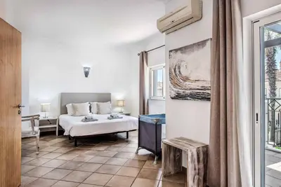 a bedroom with a bed and a desk and a window at Villa Norcas Grande in Galé