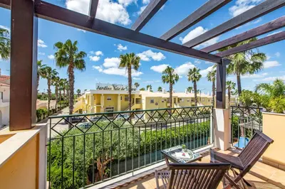 a balcony with two chairs and palm trees at Villa Norcas Grande in Galé