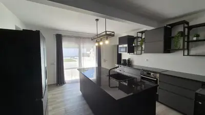 a kitchen with black cabinets and a black counter top at Villa Feliz - Large Villa - Pool in Albufeira