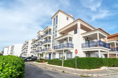 a white apartment building with balconies and a stop sign at Host Wise - Wonderful Flats with Pool in Albufeira