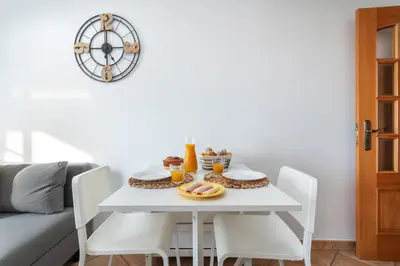 a white dining room table with white chairs and food on it at Host Wise - Wonderful Flats with Pool in Albufeira