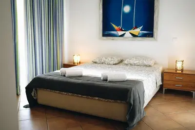 a bedroom with a bed and a painting on the wall at Host Wise - Wonderful Flats with Pool in Albufeira