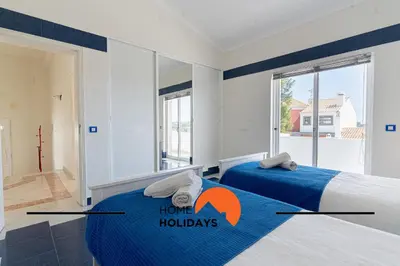 two beds in a bedroom with a home holidays sign on them at #248 Villa Loureira 54 by Home Holidays in Albufeira