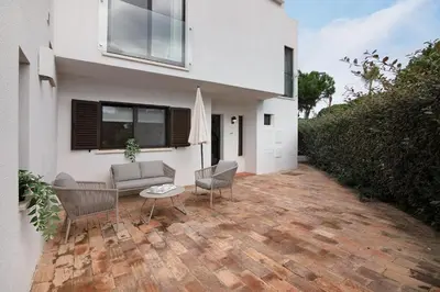 a house with a patio with a couch and chairs at Pear Tree Villa in Vale do Lobo