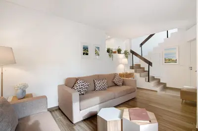a living room with a couch and a staircase at Pear Tree Villa in Vale do Lobo
