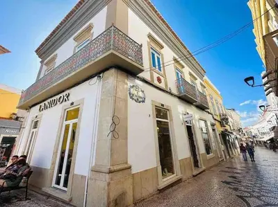 a building on a street with people sitting outside of it at Castle House Loulé City Center in Loulé