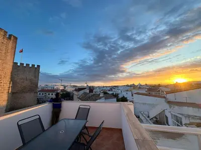a table and chairs on a balcony with a sunset at Castle House Loulé City Center in Loulé