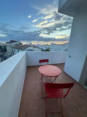 two red chairs and a table on a balcony at Castle House Loulé City Center in Loulé