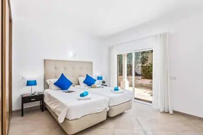 a bedroom with a large bed with blue pillows at Villa Helene Norvilla in Galé