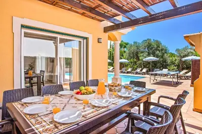 a dining room with a table and chairs and a pool at Villa Helene Norvilla in Galé
