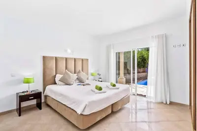 a white bedroom with a large bed and a balcony at Villa Helene Norvilla in Galé