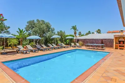 a swimming pool with lounge chairs and umbrellas at Villa Helene Norvilla in Galé