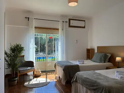 a bedroom with two beds and a large window at Moradia V2 - 200m da Praia da Oura - Santa Eulália in Albufeira