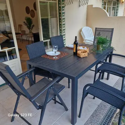 a picnic table with chairs and a bottle of wine at Moradia V2 - 200m da Praia da Oura - Santa Eulália in Albufeira