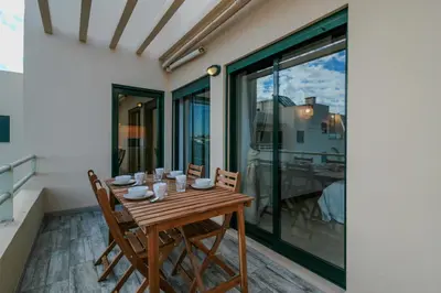 a wooden table and chairs on a balcony at FLH Salgados Balcony Flat in Albufeira