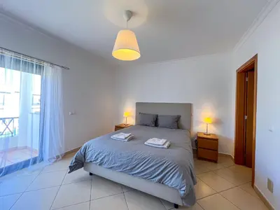 a bedroom with a bed and a large window at Charming 3-Bedroom Villa with Pool in Albufeira in Albufeira