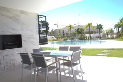a dining room with a table and chairs next to a swimming pool at Lakes 24 - Av Praia da Falésia in Quarteira