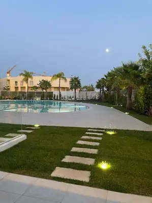 a swimming pool with lights in the grass at Lakes 24 - Av Praia da Falésia in Quarteira