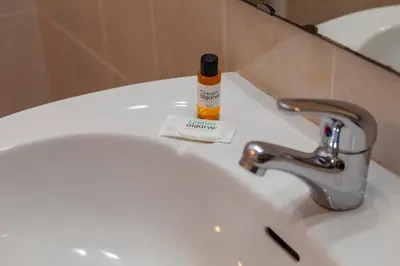 a bathroom sink with a bottle of soap on it at Seacliff Albufeira in Albufeira