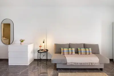 a living room with a couch and a mirror at Magnificent Beach Apartment in Albufeira