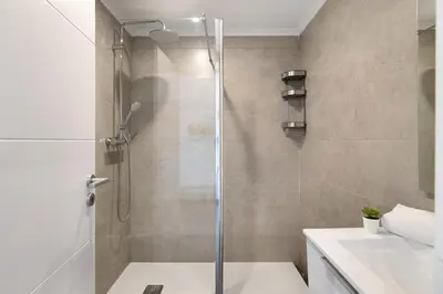 a shower with a glass door in a bathroom at Magnificent Beach Apartment in Albufeira