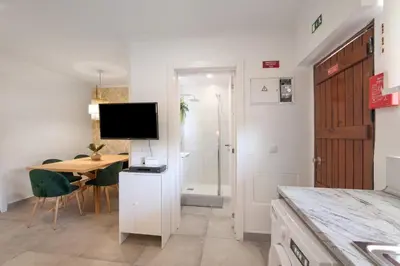 a kitchen and dining room with a table and a television at Stunning Modern Apartment In Oura in Albufeira
