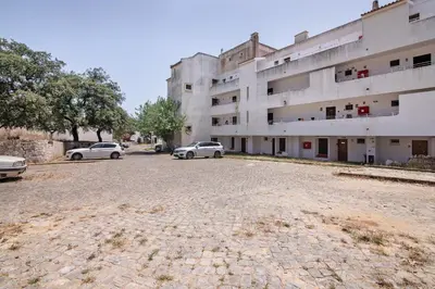 a building with a retaining wall and a car parked in front at Stunning Modern Apartment In Oura in Albufeira
