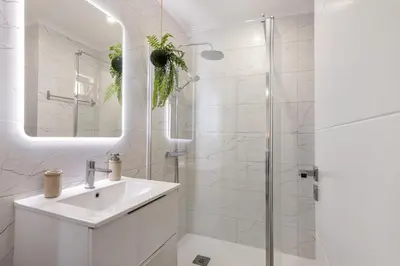 a white bathroom with a sink and a shower at Stunning Modern Apartment In Oura in Albufeira