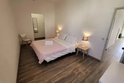 a bedroom with a bed and two tables and a mirror at Sea View Apartment Faro in Faro